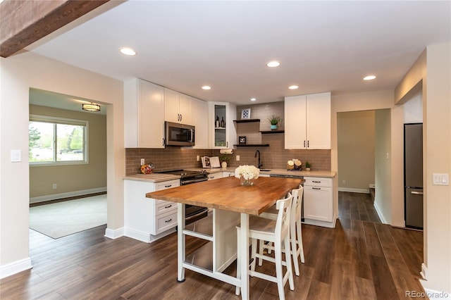 8160 W Phillips Ave, Littleton, CO 80128 - kitchen with appliances with stainless steel finishes, wood counters, open shelves, white cabinets, and decorative backsplash