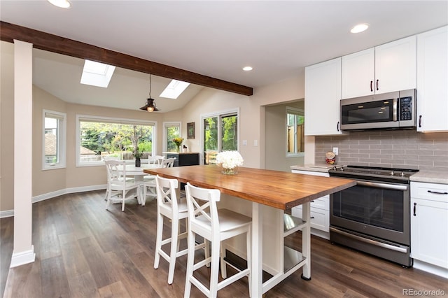 8160 W Phillips Ave, Littleton, CO 80128 - kitchen with appliances with stainless steel finishes, butcher block counters, a skylight, decorative backsplash, and white cabinets