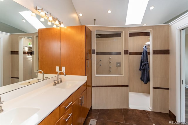 8160 W Phillips Ave, Littleton, CO 80128 - bathroom featuring a skylight, double vanity, tile patterned flooring, walk in shower, and vaulted ceiling