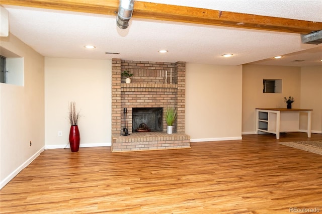 8160 W Phillips Ave, Littleton, CO 80128 - unfurnished living room featuring light wood-style floors, a textured ceiling, recessed lighting, and a brick fireplace