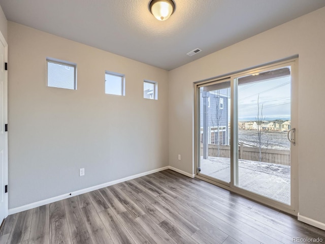 spare room featuring a textured ceiling and hardwood / wood-style floors