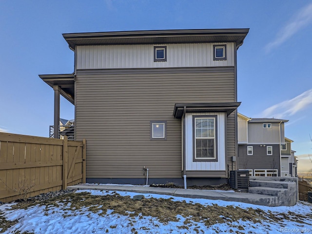 snow covered property with central air condition unit