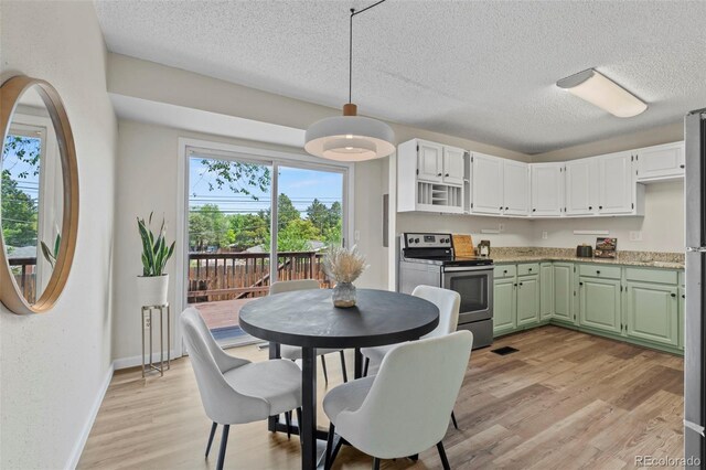 818 Don Juan Ct, Colorado Springs, CO 80909 - dining area featuring a textured ceiling, light wood finished floors, and baseboards