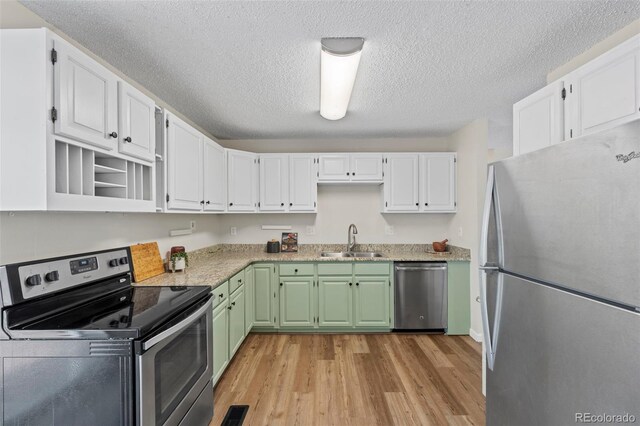 818 Don Juan Ct, Colorado Springs, CO 80909 - kitchen with stainless steel appliances, a sink, light wood finished floors, white cabinets, and open shelves
