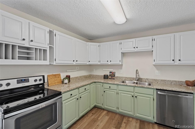 818 Don Juan Ct, Colorado Springs, CO 80909 - kitchen featuring appliances with stainless steel finishes, a sink, white cabinets, light wood-type flooring, and a textured ceiling