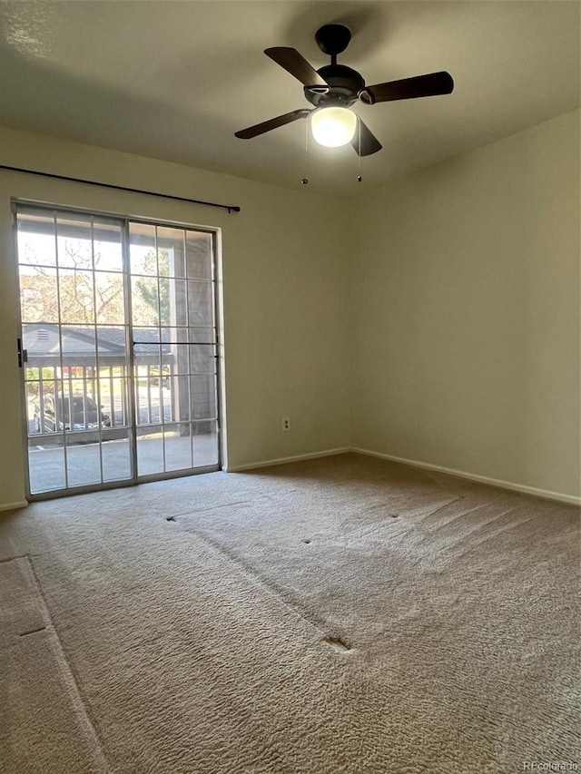 empty room featuring a ceiling fan, carpet flooring, and baseboards