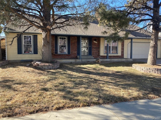 ranch-style house with a garage, roof with shingles, a front lawn, and brick siding