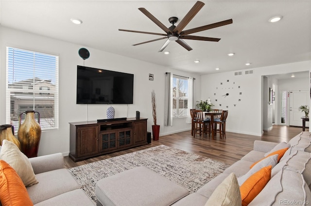 living room featuring dark wood-type flooring and ceiling fan