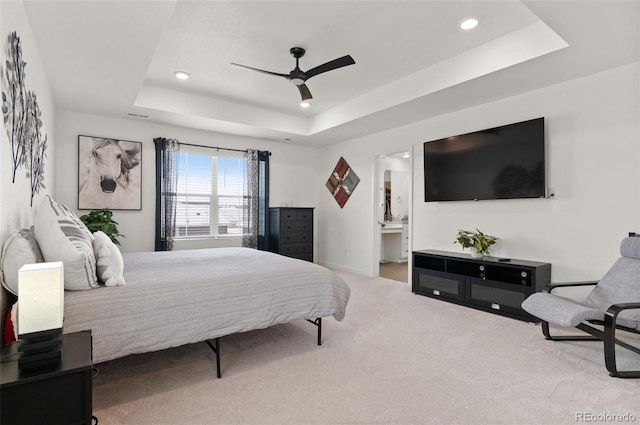 carpeted bedroom featuring ceiling fan, connected bathroom, and a raised ceiling