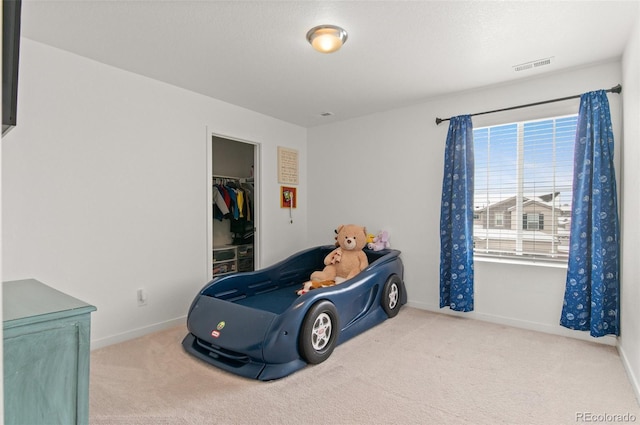 bedroom featuring carpet, a spacious closet, and a closet