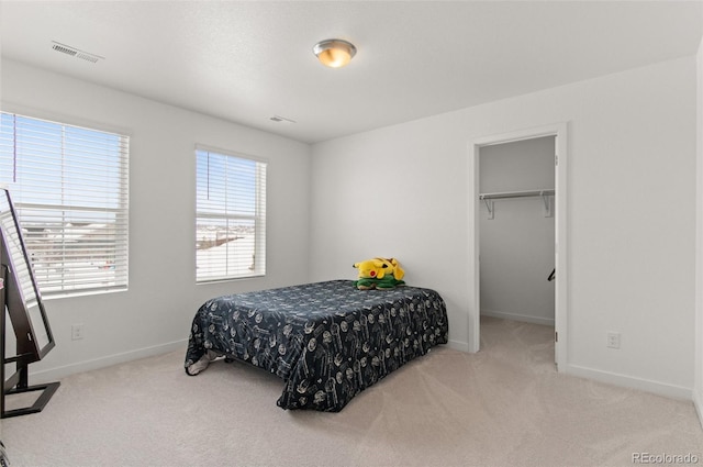 carpeted bedroom featuring a walk in closet