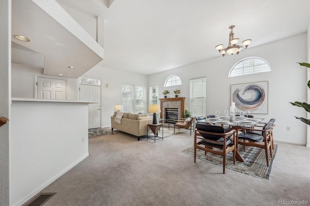 carpeted dining space featuring an inviting chandelier and a healthy amount of sunlight