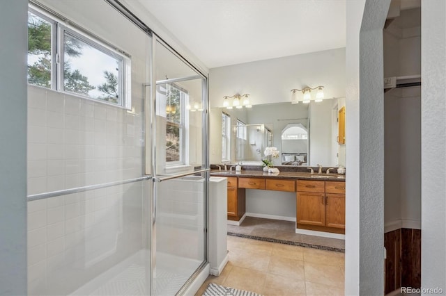 bathroom with tile patterned floors, a shower with door, and vanity