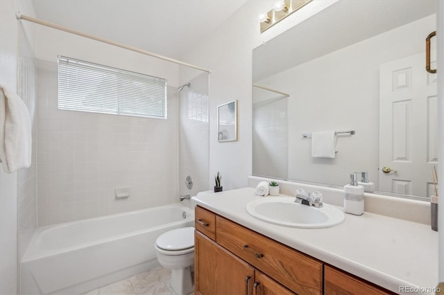 full bathroom featuring tiled shower / bath combo, vanity, and toilet