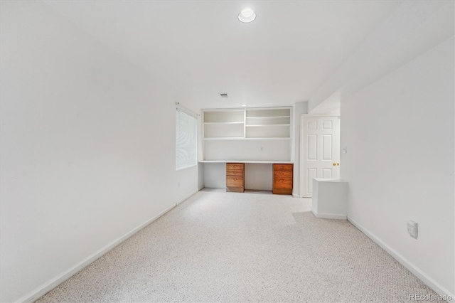 unfurnished living room featuring built in desk