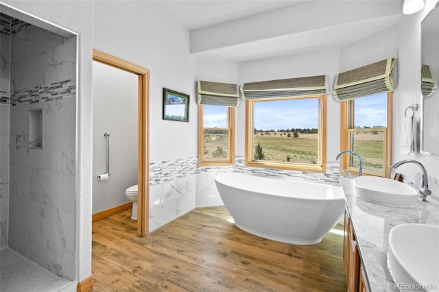 full bathroom featuring hardwood / wood-style flooring, vanity, separate shower and tub, and toilet