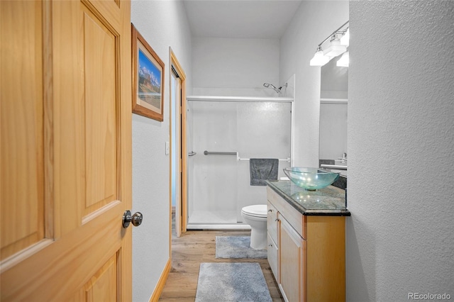 bathroom with vanity, hardwood / wood-style flooring, toilet, and an enclosed shower