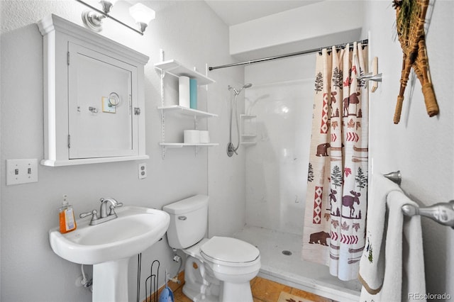 bathroom featuring a shower with shower curtain, toilet, and sink