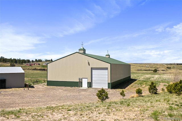 view of outbuilding with a rural view and a garage