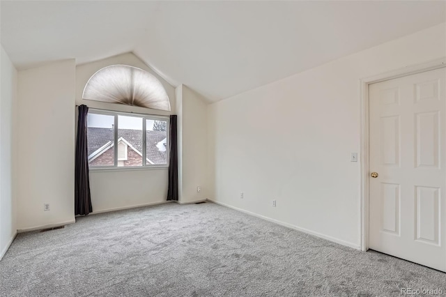 carpeted spare room featuring lofted ceiling