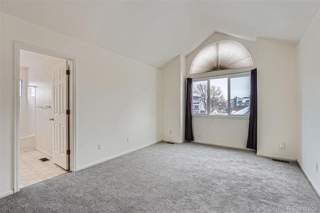 carpeted empty room featuring lofted ceiling