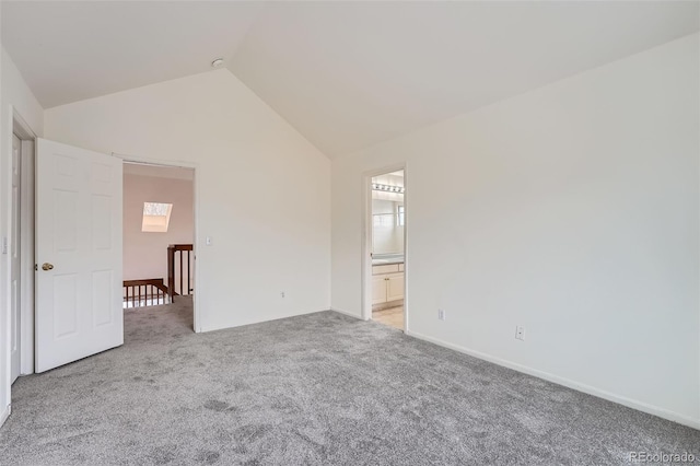 carpeted empty room with lofted ceiling