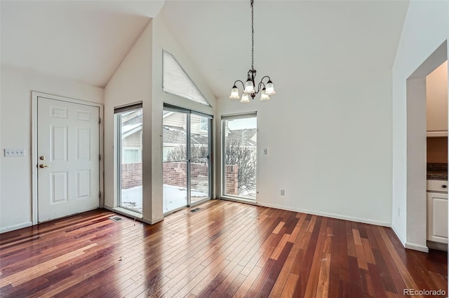 unfurnished dining area with a chandelier, dark hardwood / wood-style floors, and high vaulted ceiling