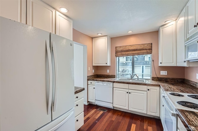 kitchen featuring sink, white appliances, white cabinets, and dark hardwood / wood-style floors