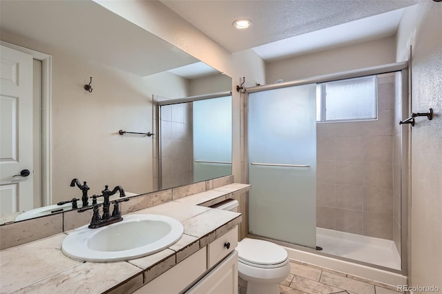 bathroom featuring toilet, a shower with shower door, and vanity