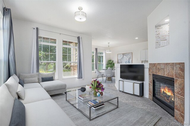 3000 E 112th Ave Unit 61, Northglenn, CO 80233 - carpeted living area with a tiled fireplace, a chandelier, and recessed lighting