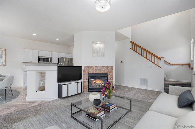 3000 E 112th Ave Unit 61, Northglenn, CO 80233 - living area featuring stairs, a tiled fireplace, and recessed lighting