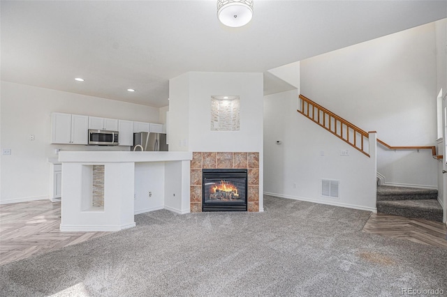 3000 E 112th Ave Unit 61, Northglenn, CO 80233 - unfurnished living room with stairway, a fireplace, recessed lighting, and light carpet