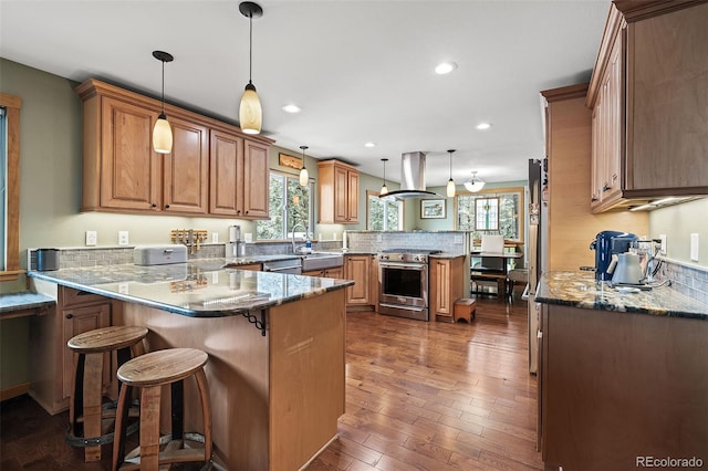 2857 Hiwan Dr, Evergreen, CO 80439 - kitchen with plenty of natural light, a peninsula, range hood, and appliances with stainless steel finishes