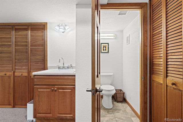 2857 Hiwan Dr, Evergreen, CO 80439 - bathroom with a textured ceiling, a closet, vanity, visible vents, and toilet