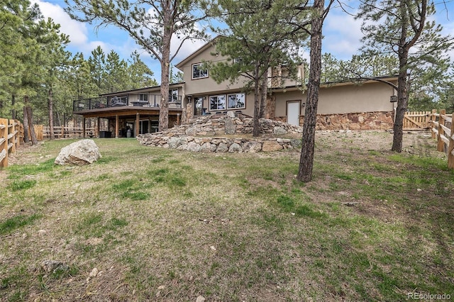 2857 Hiwan Dr, Evergreen, CO 80439 - back of property with a lawn, stucco siding, a fenced backyard, and a wooden deck