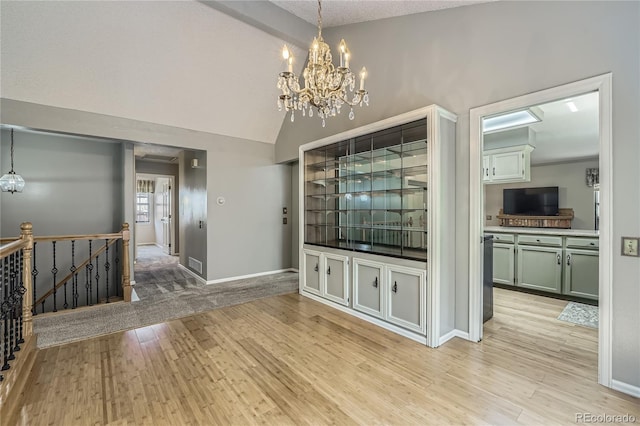 8164 Flower Cir, Arvada, CO 80005 - unfurnished dining area featuring a chandelier, light wood-style flooring, baseboards, and high vaulted ceiling