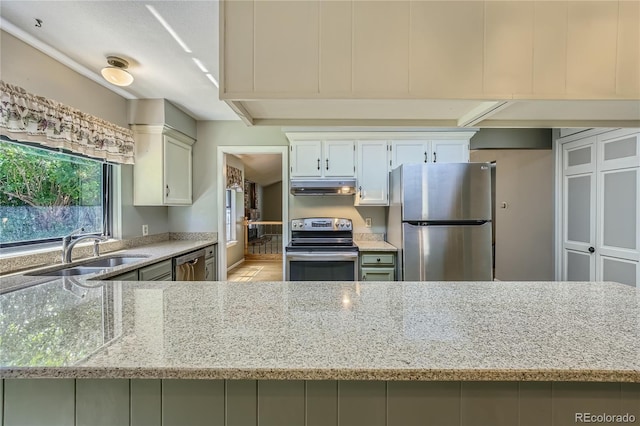 8164 Flower Cir, Arvada, CO 80005 - kitchen with stainless steel appliances, under cabinet range hood, a sink, and light stone counters