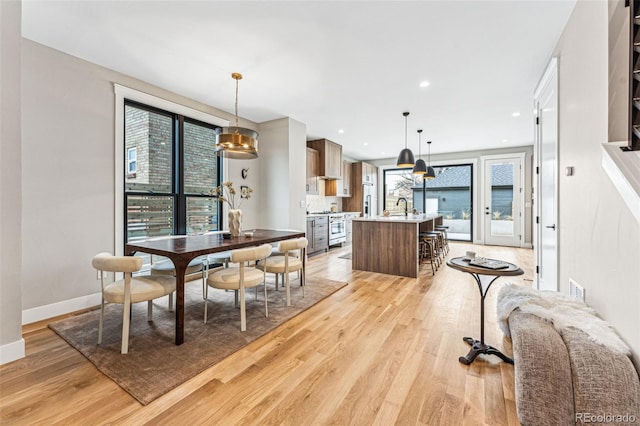 dining area with light wood-type flooring and sink