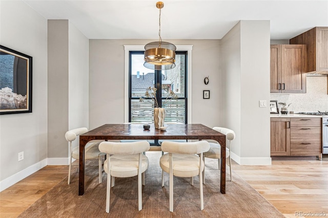 dining area with a notable chandelier and light hardwood / wood-style flooring