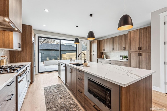 kitchen featuring tasteful backsplash, a kitchen island with sink, stainless steel appliances, and decorative light fixtures