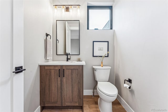 bathroom with vanity, toilet, and wood-type flooring