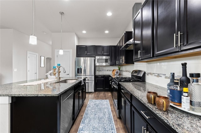 kitchen featuring pendant lighting, sink, appliances with stainless steel finishes, a center island with sink, and dark hardwood / wood-style flooring