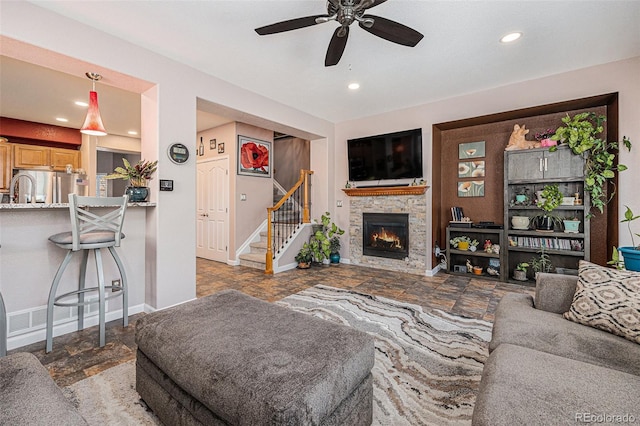 860 Bristle Pine Cir Unit A, Highlands Ranch, CO 80129 - living area featuring a ceiling fan, stairs, recessed lighting, a stone fireplace, and stone finish flooring