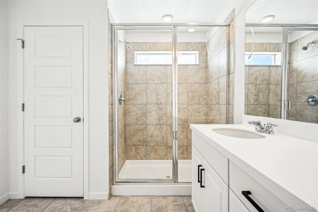 bathroom featuring a stall shower, baseboards, and vanity