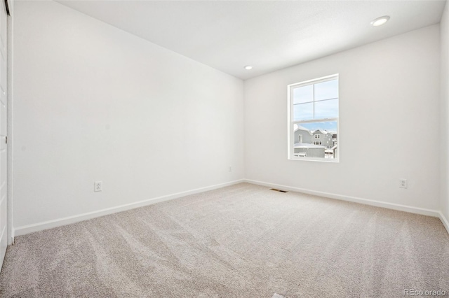 unfurnished room with light carpet, baseboards, visible vents, and recessed lighting