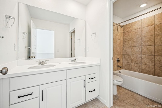 full bathroom with toilet, double vanity, a sink, and shower / bathtub combination