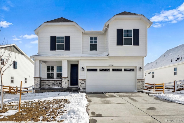 view of front of house featuring driveway, stone siding, an attached garage, fence, and a porch