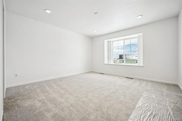 carpeted empty room featuring visible vents, baseboards, and recessed lighting