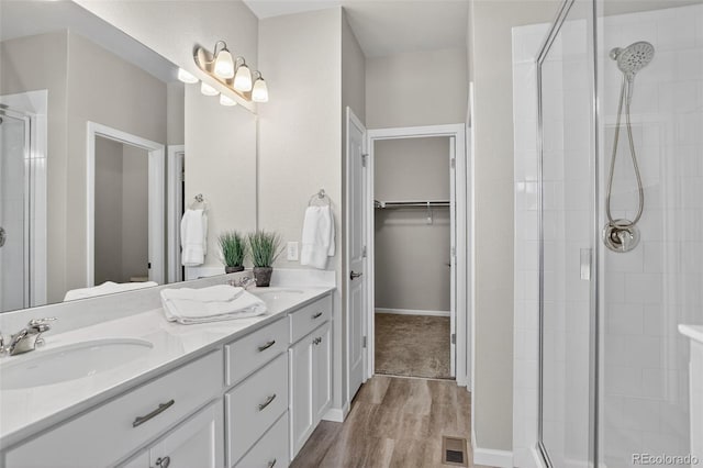 19629 W 93rd Dr Unit C, Arvada, CO 80007 - bathroom with a stall shower, wood finished floors, double vanity, and a walk in closet