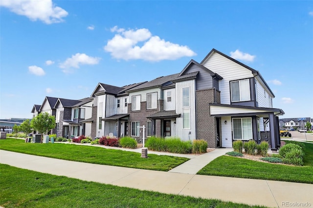 19629 W 93rd Dr Unit C, Arvada, CO 80007 - view of property featuring a residential view, a front yard, and brick siding